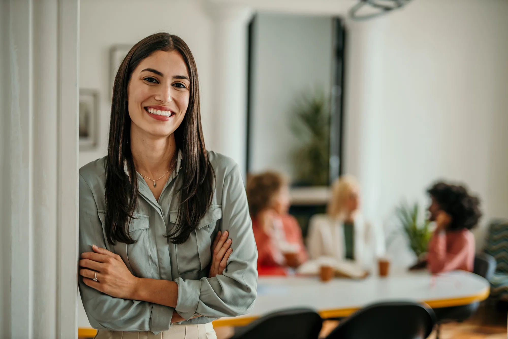 Lächelnde Business-Frau vor Team-Meeting als Beispiel für eine professionelle Website