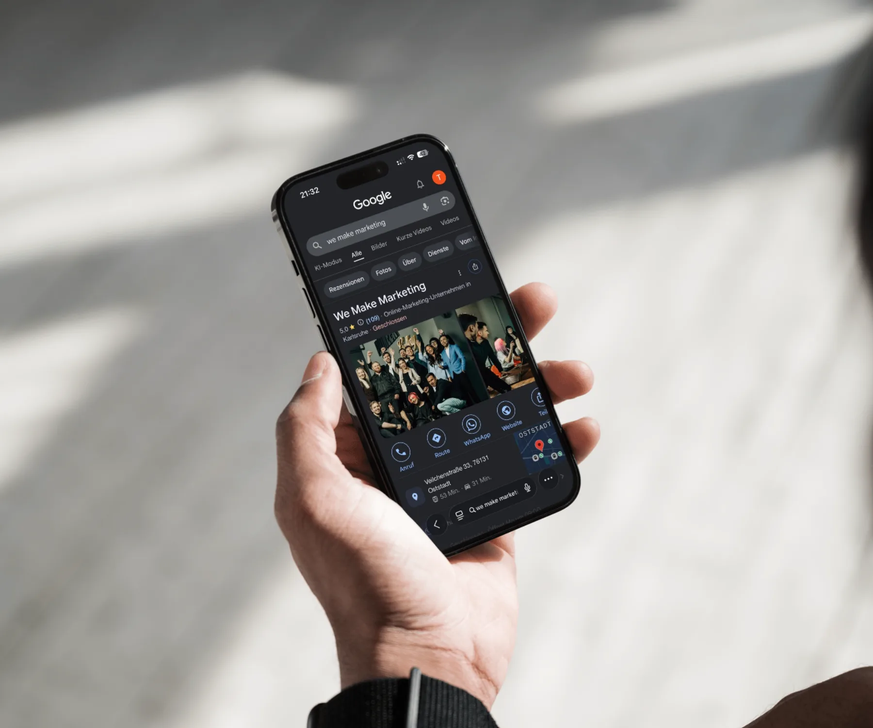 Hand hält Smartphone mit Google Unternehmensprofil der Online-Marketing-Agentur we make marketing Karlsruhe
