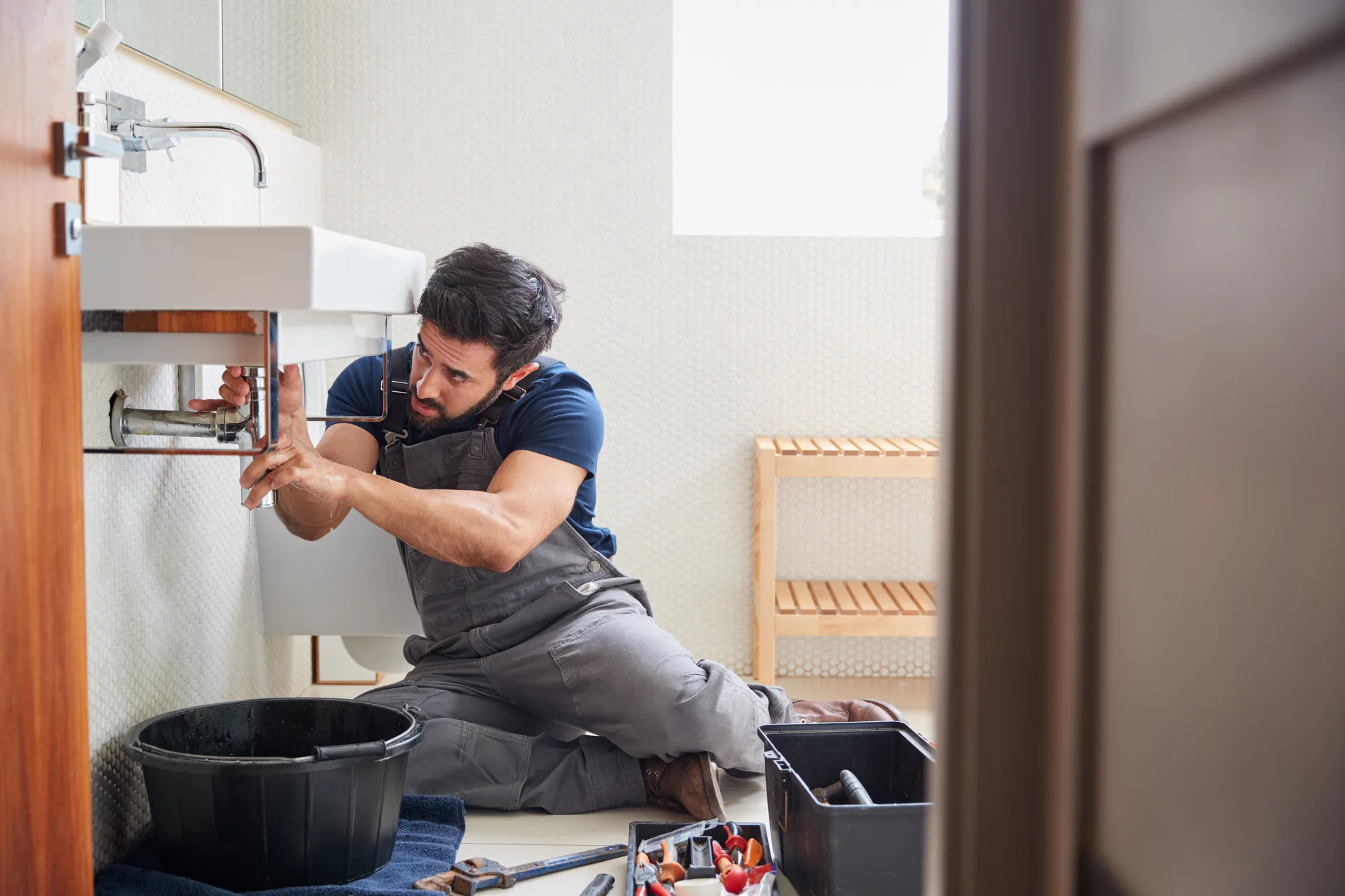 Klempner repariert Waschbecken im Bad, eine professionelle Website schafft professionellen Online-Auftritt