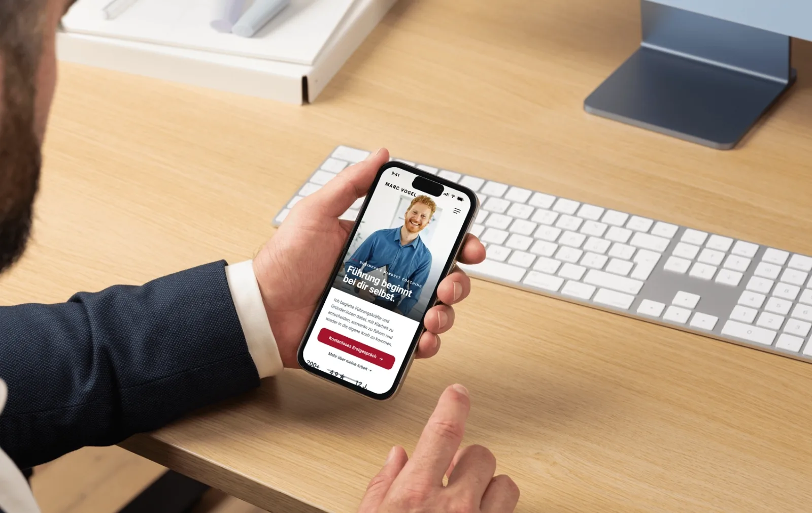 Smartphone in der Hand zeigt eine Coaching-Landingpage mit Call-to-Action