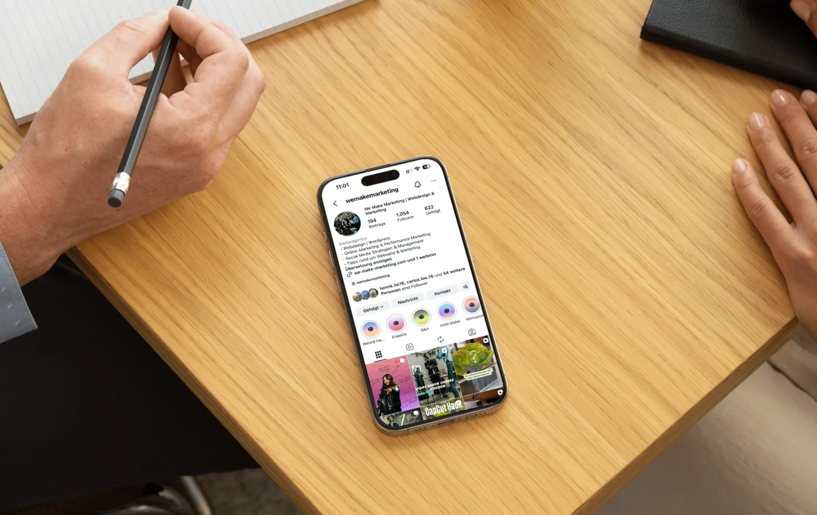 Smartphone auf einem Schreibtisch zeigt das Instagram-Profil von we make marketing