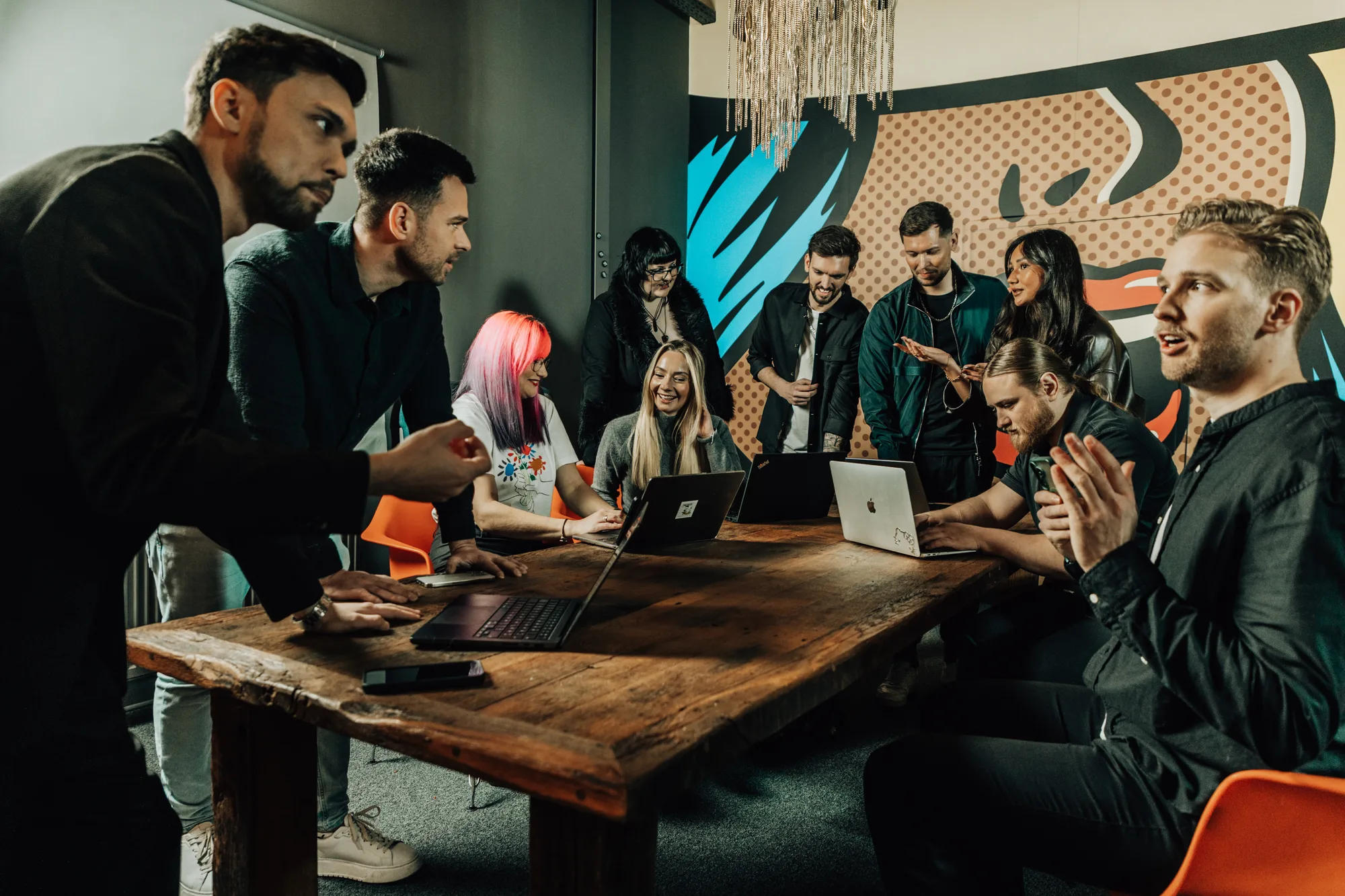 Das Team von we make marketing arbeitet gemeinsam an Laptops im Büro