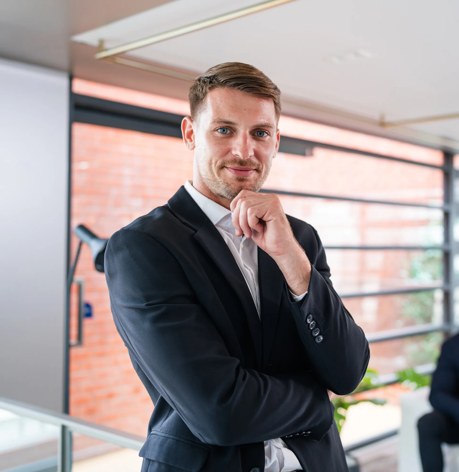 Professioneller Coach im dunklen Anzug lächelt selbstbewusst – SEO für Coaches steigert Sichtbarkeit