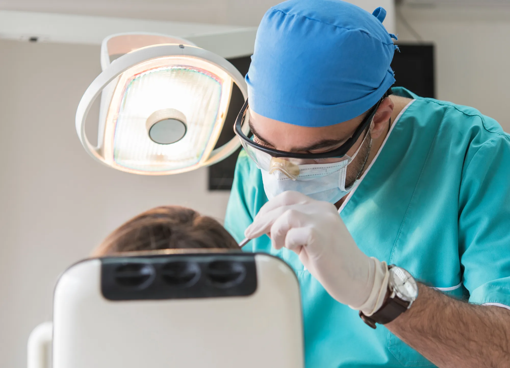 Zahnarzt mit Maske und Handschuhen behandelt Patientin, eine professionelle Website stärkt die Praxispräsenz online